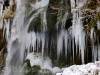 Eiszapfen in Hohlräumen hinter dem Wasserfall